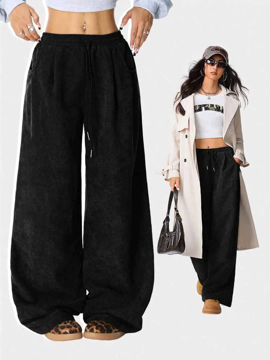 Black wide-leg pants worn by a person on a white background