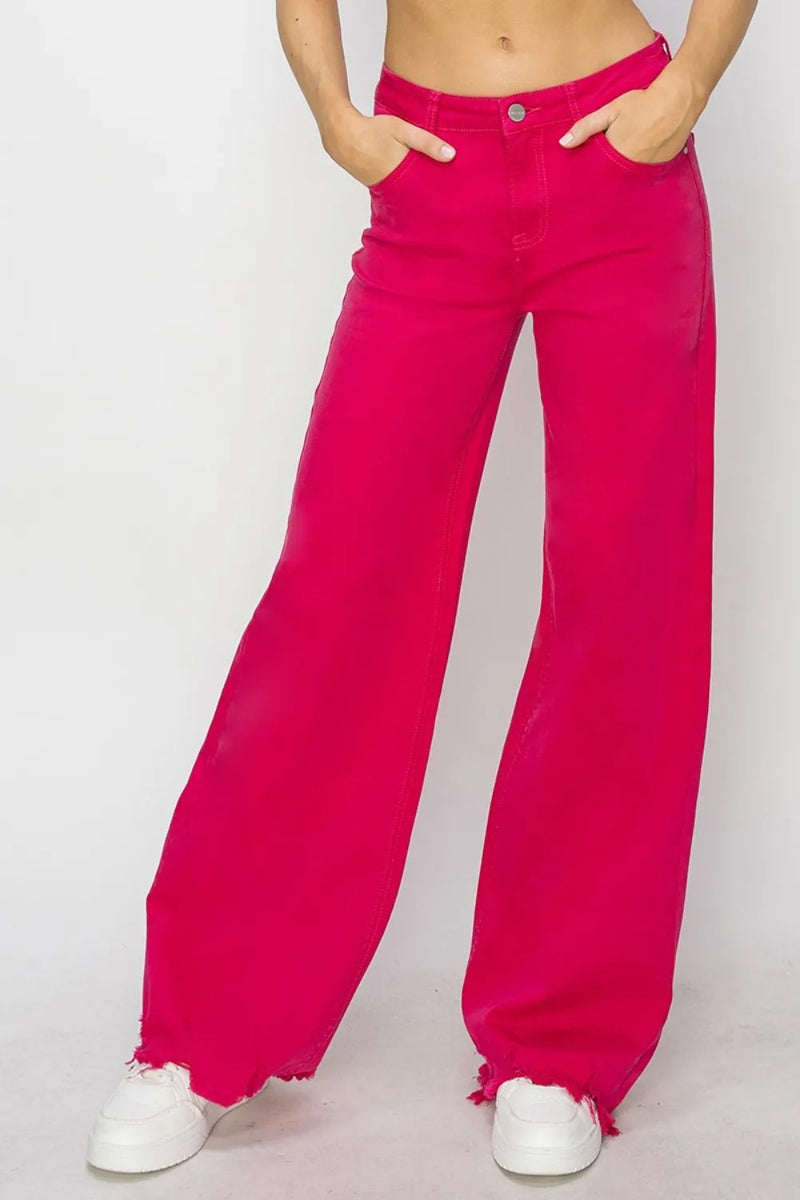 Person wearing bright pink wide-leg pants on a white background