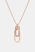 Rose gold necklace with a unique pendant on a light gray background