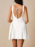 White dress with open back on a plain background