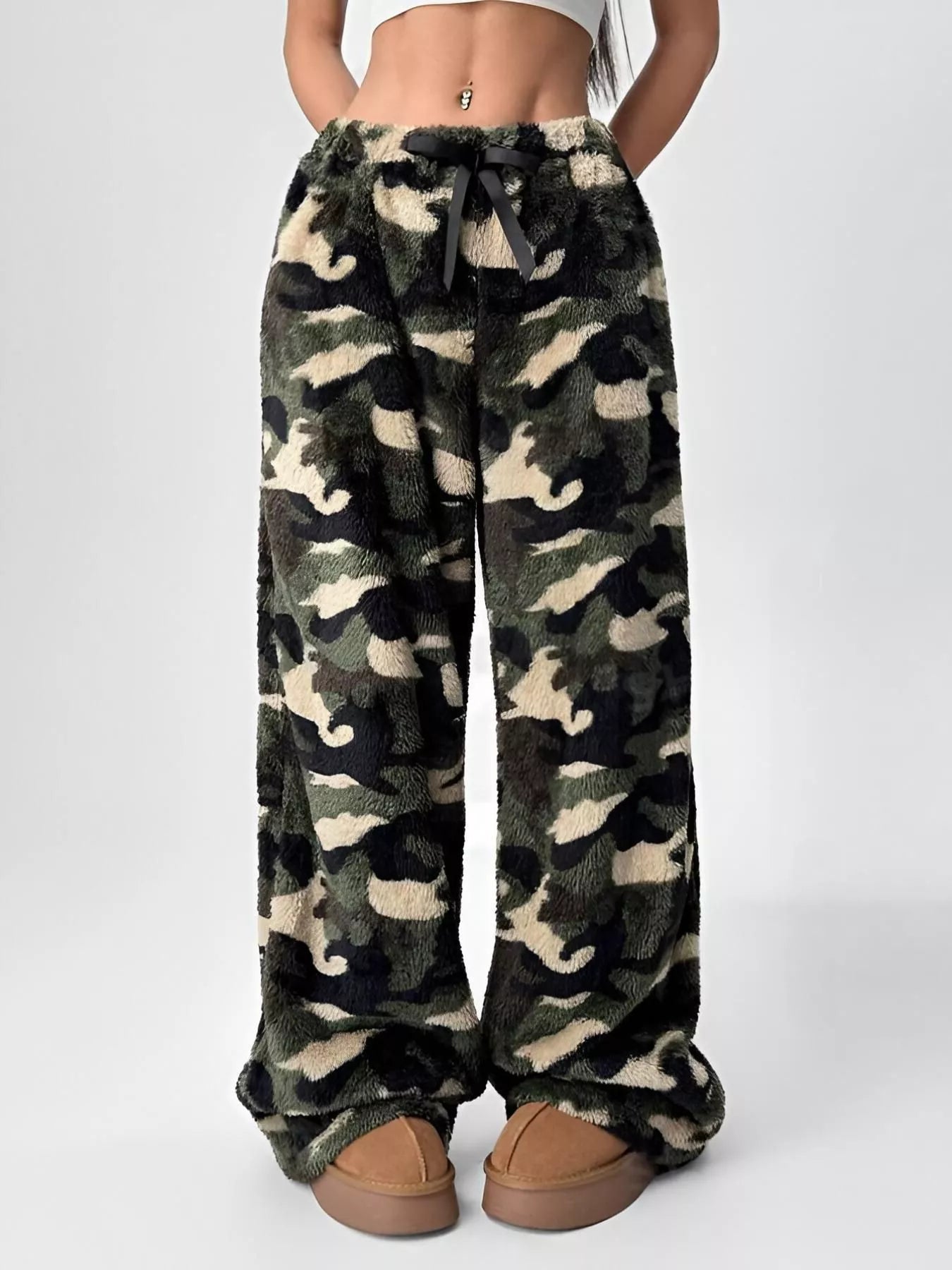Camouflage patterned pants worn by a person on a white background