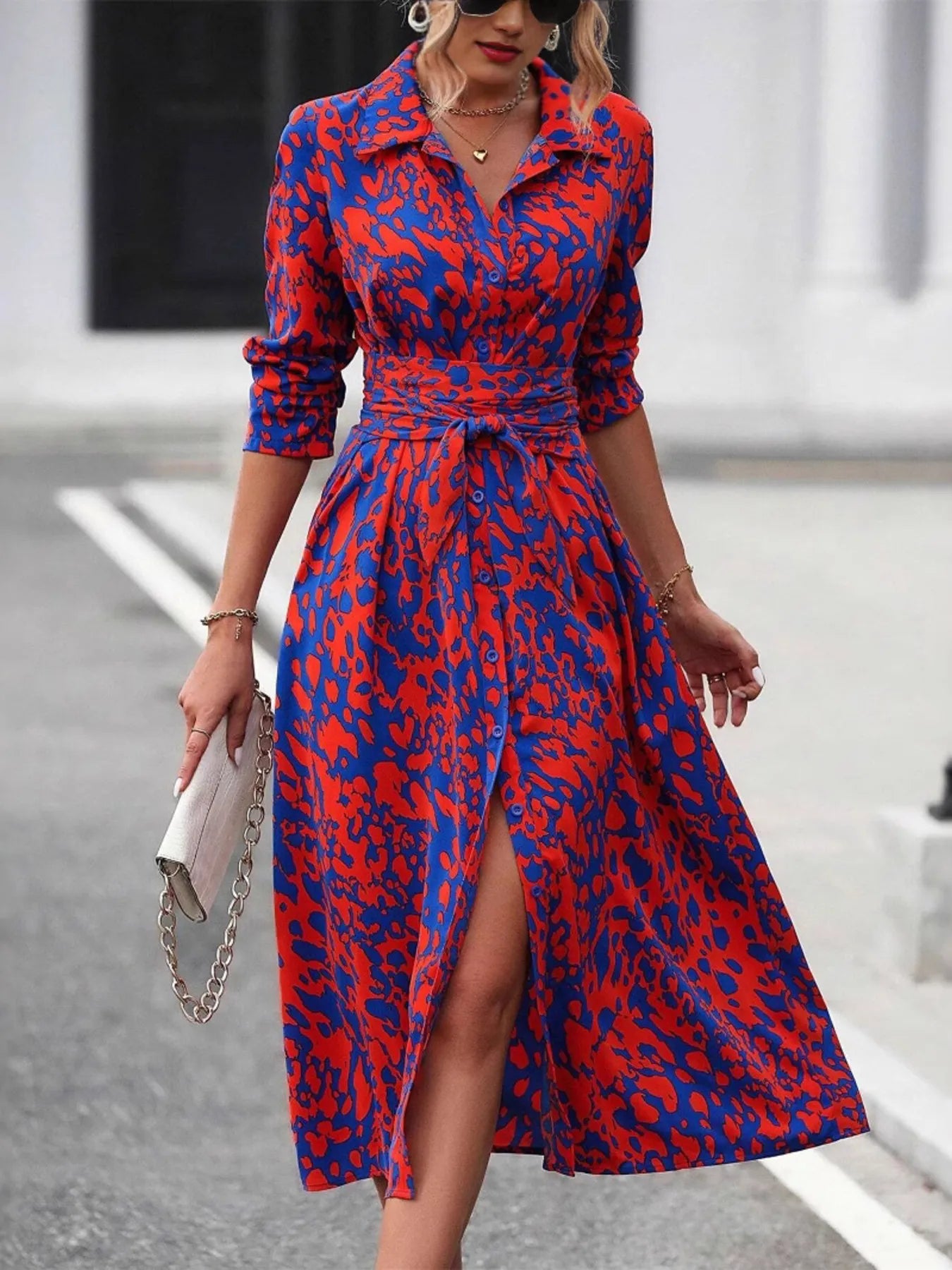 Woman wearing a red and blue patterned dress on a street.