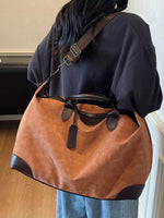Person wearing a brown and black shoulder bag indoors