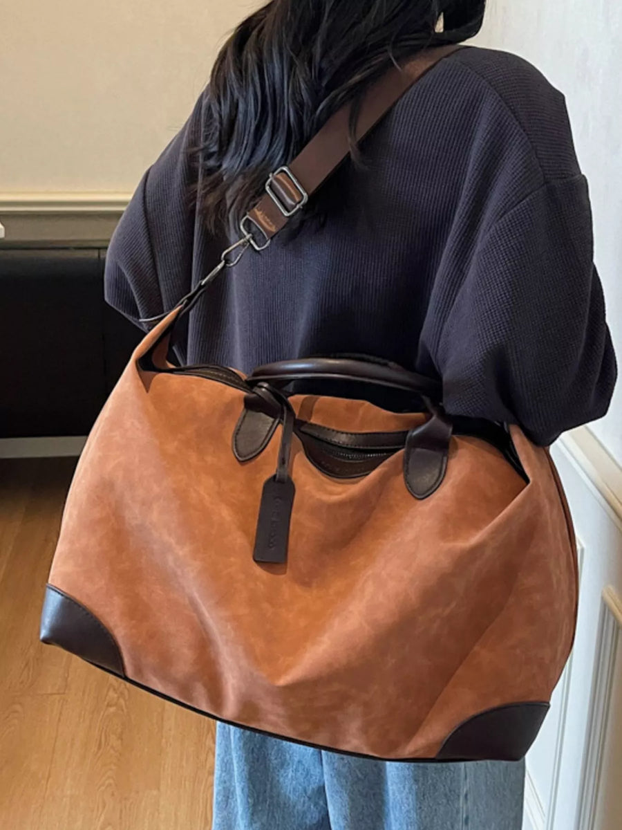 Person wearing a brown and black shoulder bag indoors