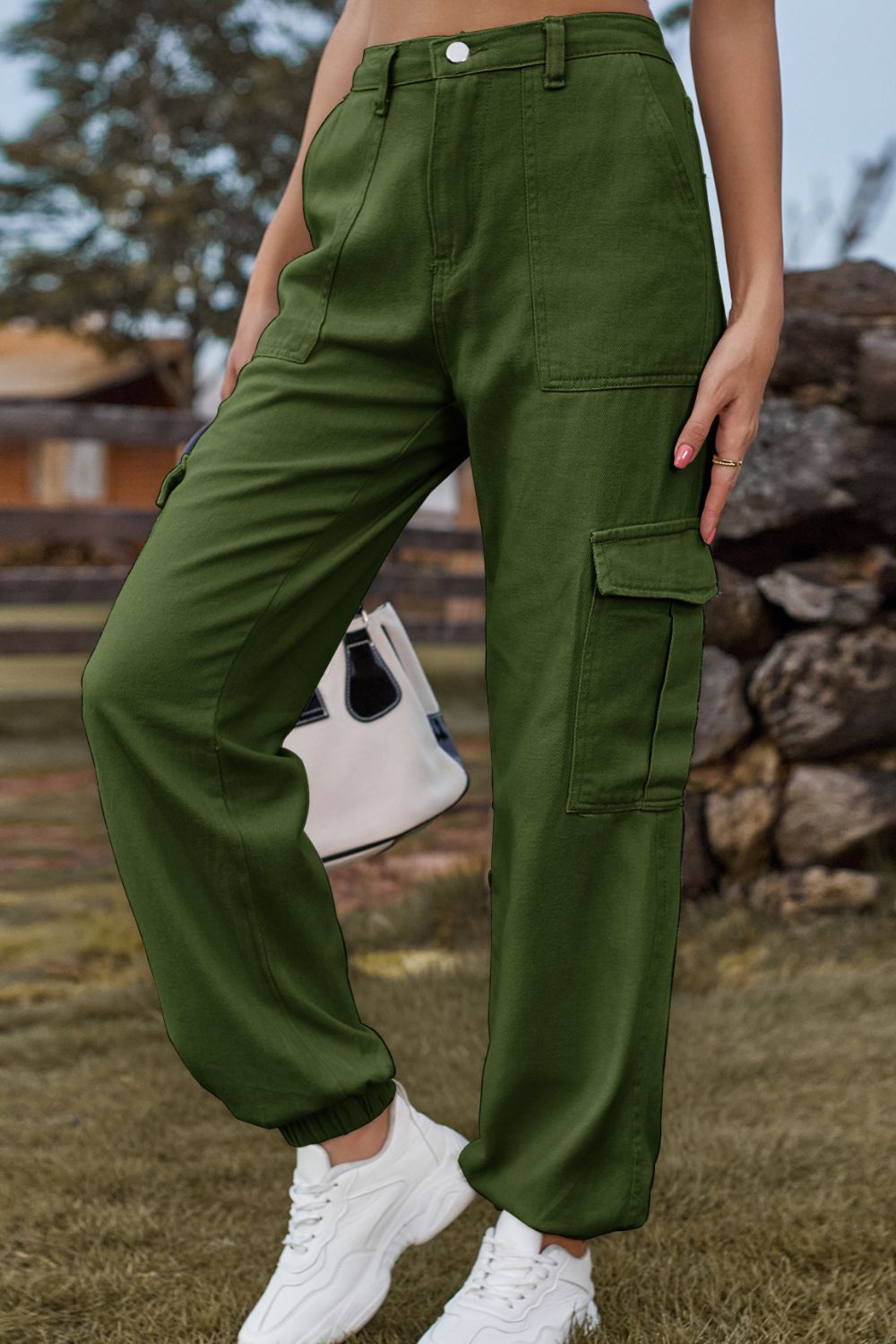 Person wearing green cargo pants standing outdoors with a blurred background