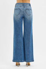 Blue jeans with heart cutouts on a white background