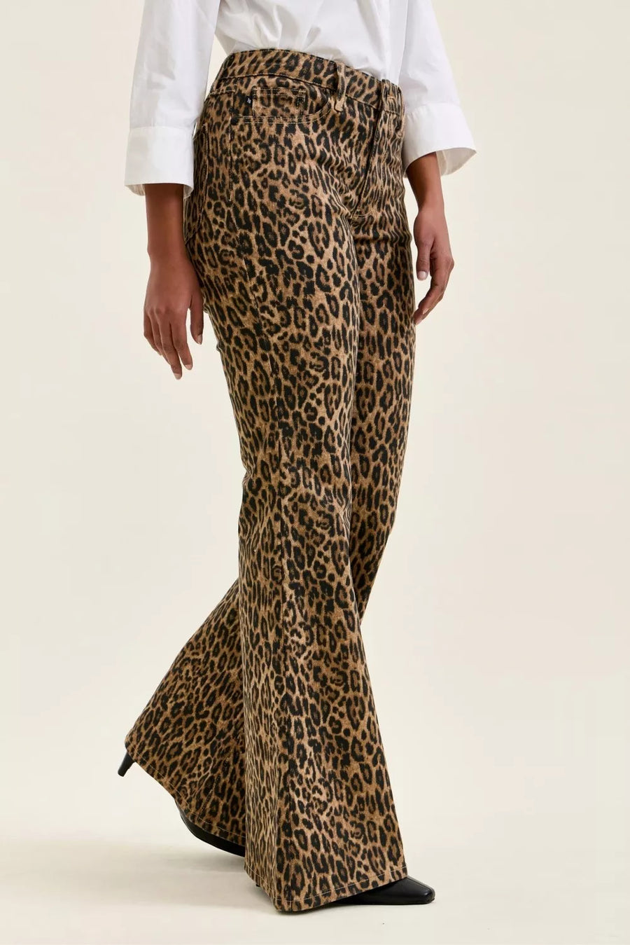 Leopard print flared pants worn by a person on a beige background