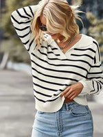 Woman wearing a black and white striped sweater and blue jeans outdoors.