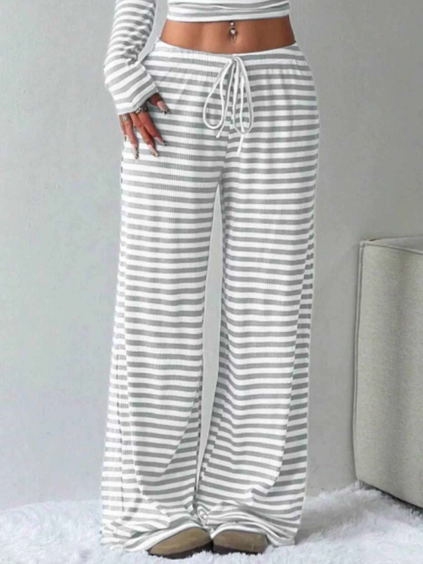 Striped pants worn by a person on a light gray background