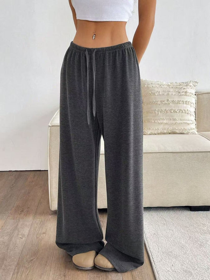 Person wearing gray wide-leg pants in a living room setting