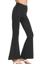 Black flared pants worn by a person on a white background