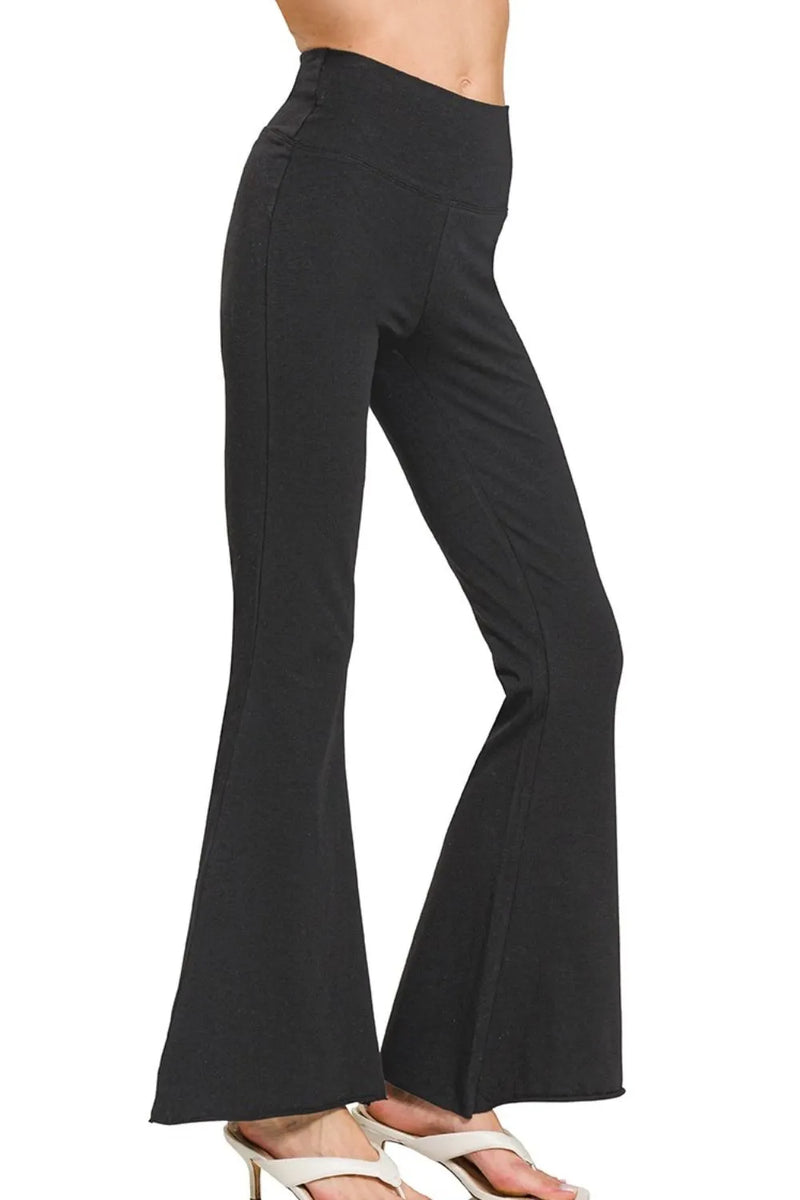 Black flared pants worn by a person on a white background