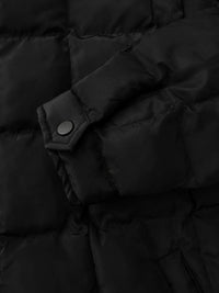 Close-up of a black puffer jacket with a button detail