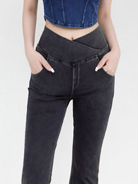 Person wearing black high-waisted jeans with a white background