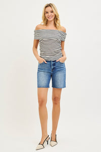 Woman wearing a striped top and denim shorts on a white background