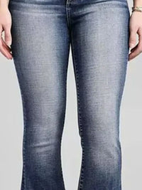 Blue jeans worn by a person on a plain background