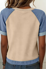 Beige and blue baseball-style shirt worn by a person against a neutral background