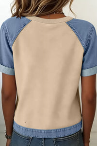 Beige and blue baseball-style shirt worn by a person against a neutral background