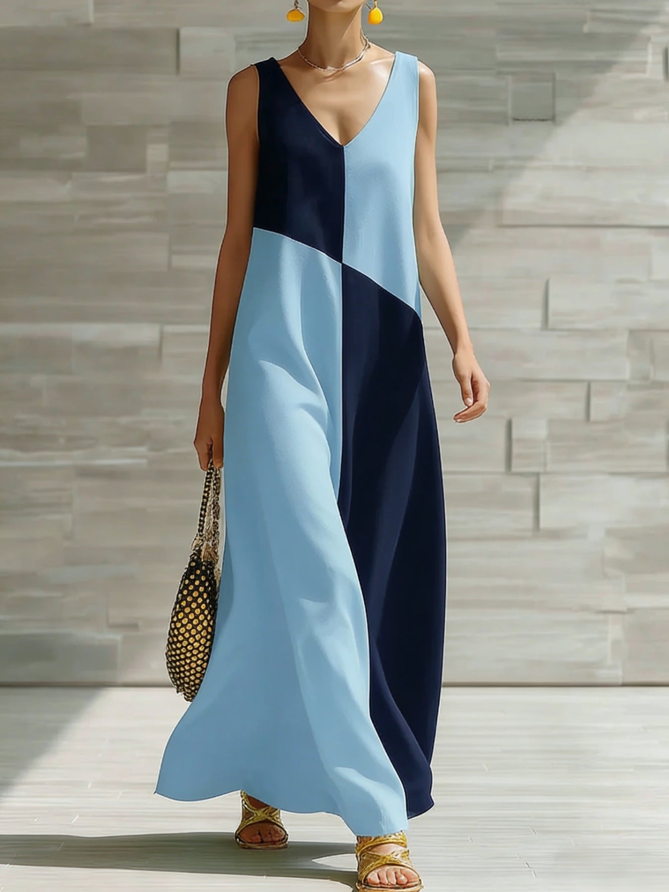 Woman wearing a blue and navy color-blocked dress against a stone wall.