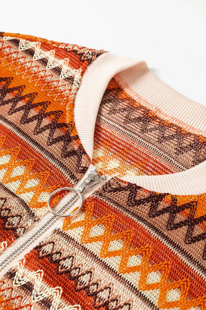 Close-up of a patterned garment with a zipper, featuring orange, brown, and beige colors.
