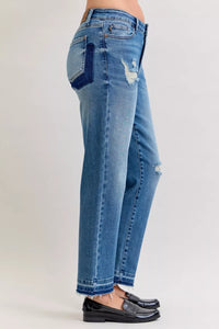 Blue jeans with distressed details on a plain background
