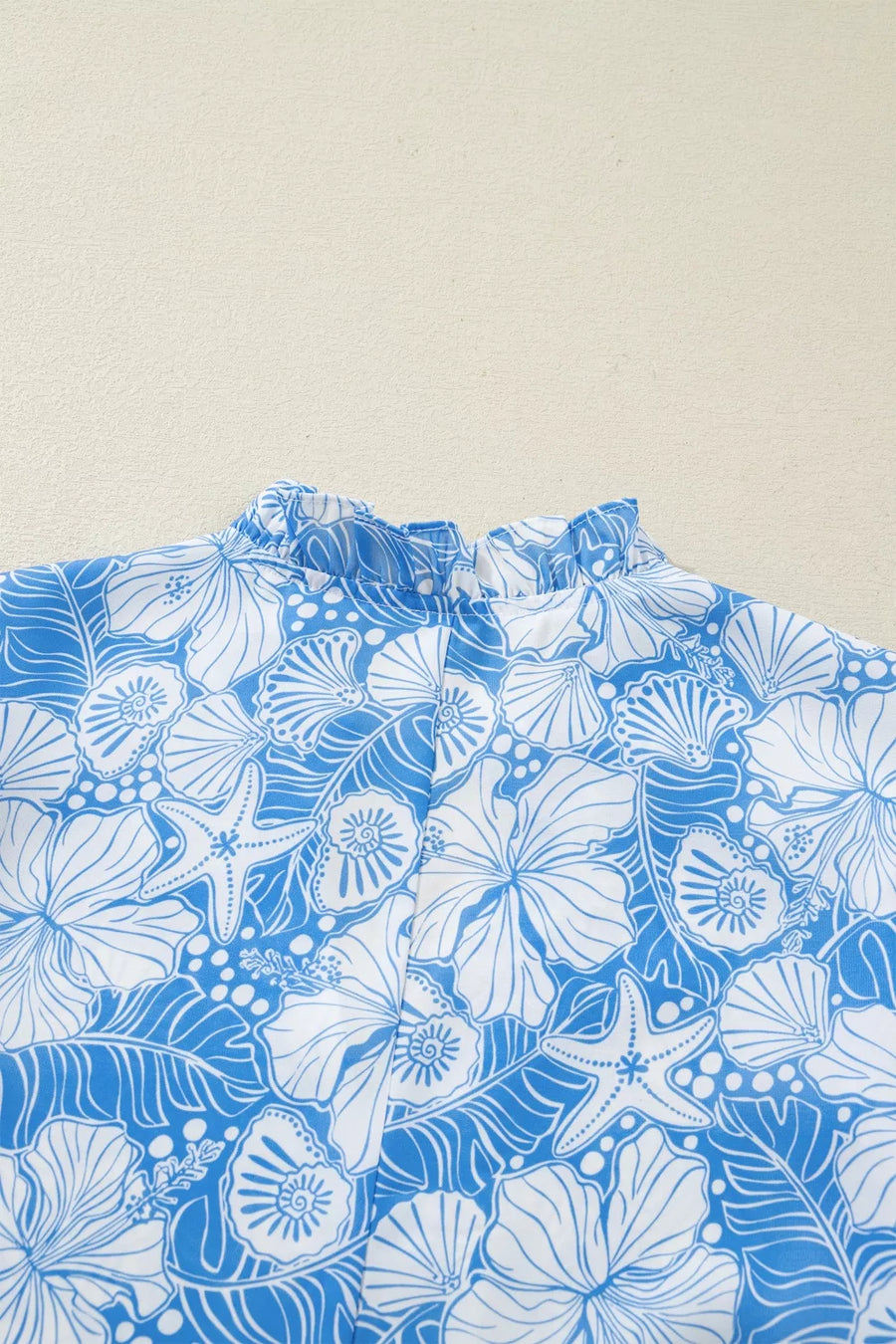 Blue and white floral patterned fabric on a beige background