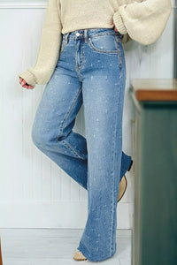 Person wearing blue jeans and a beige sweater in a kitchen setting