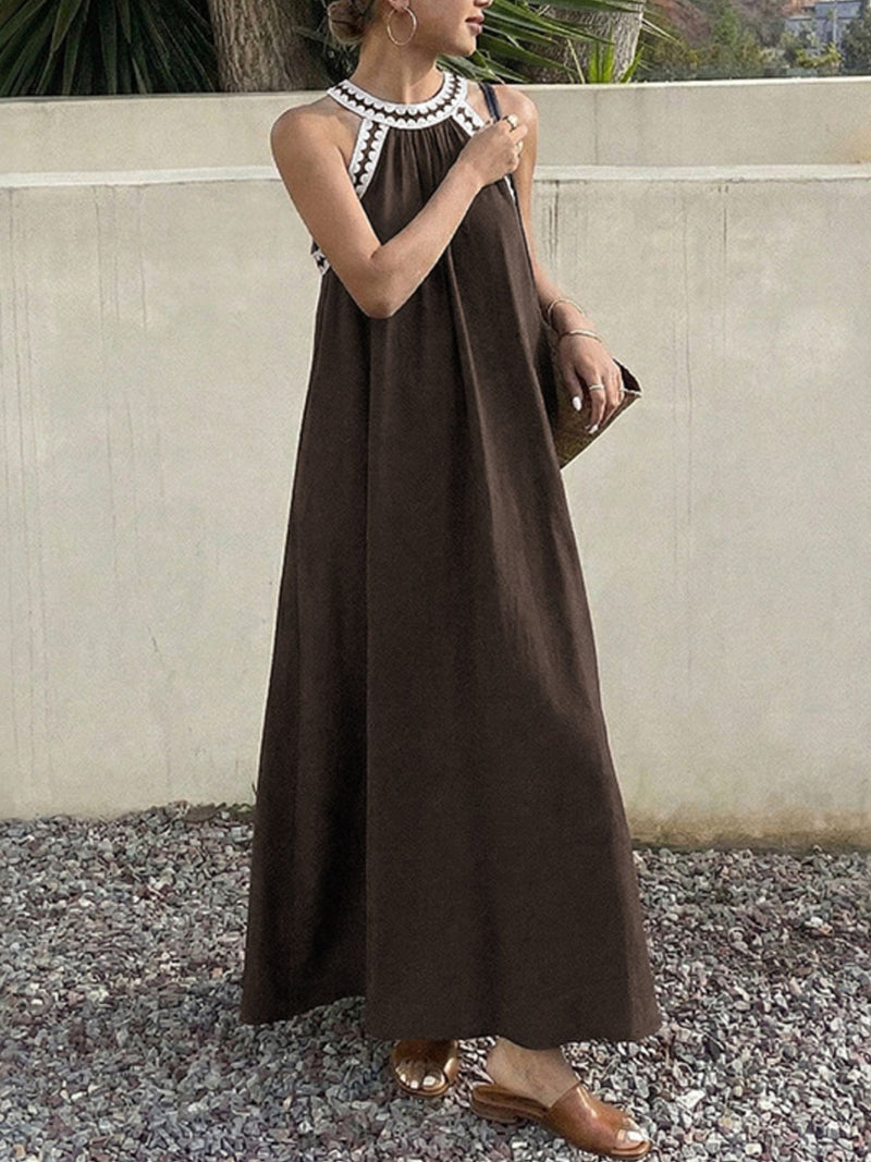 Woman wearing a brown dress with a white collar against a neutral background