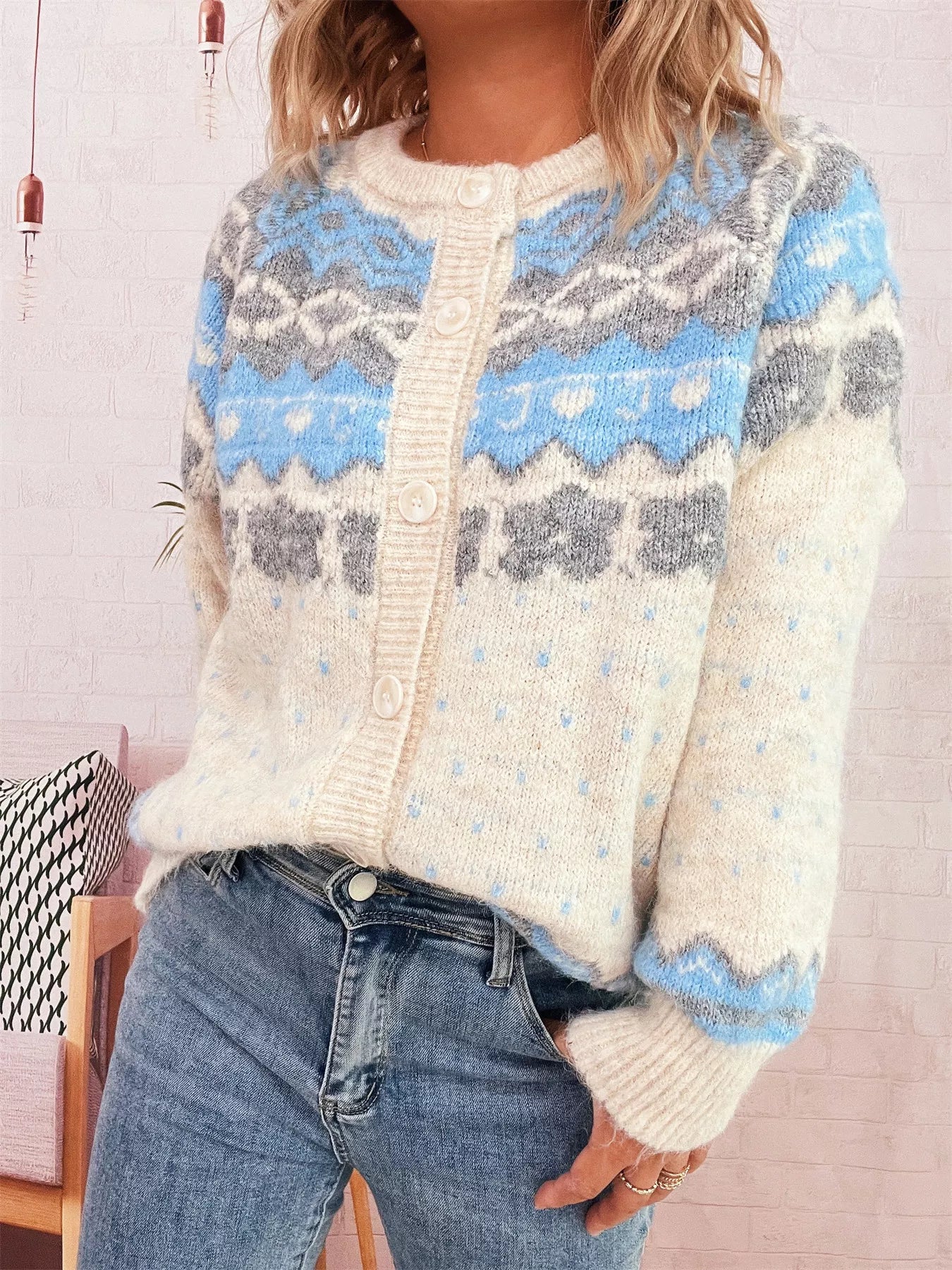 Person wearing a patterned sweater with blue, gray, and white colors.