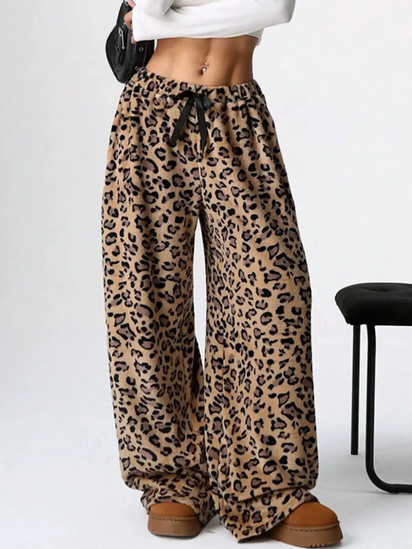 Leopard print pants worn by a person on a white background