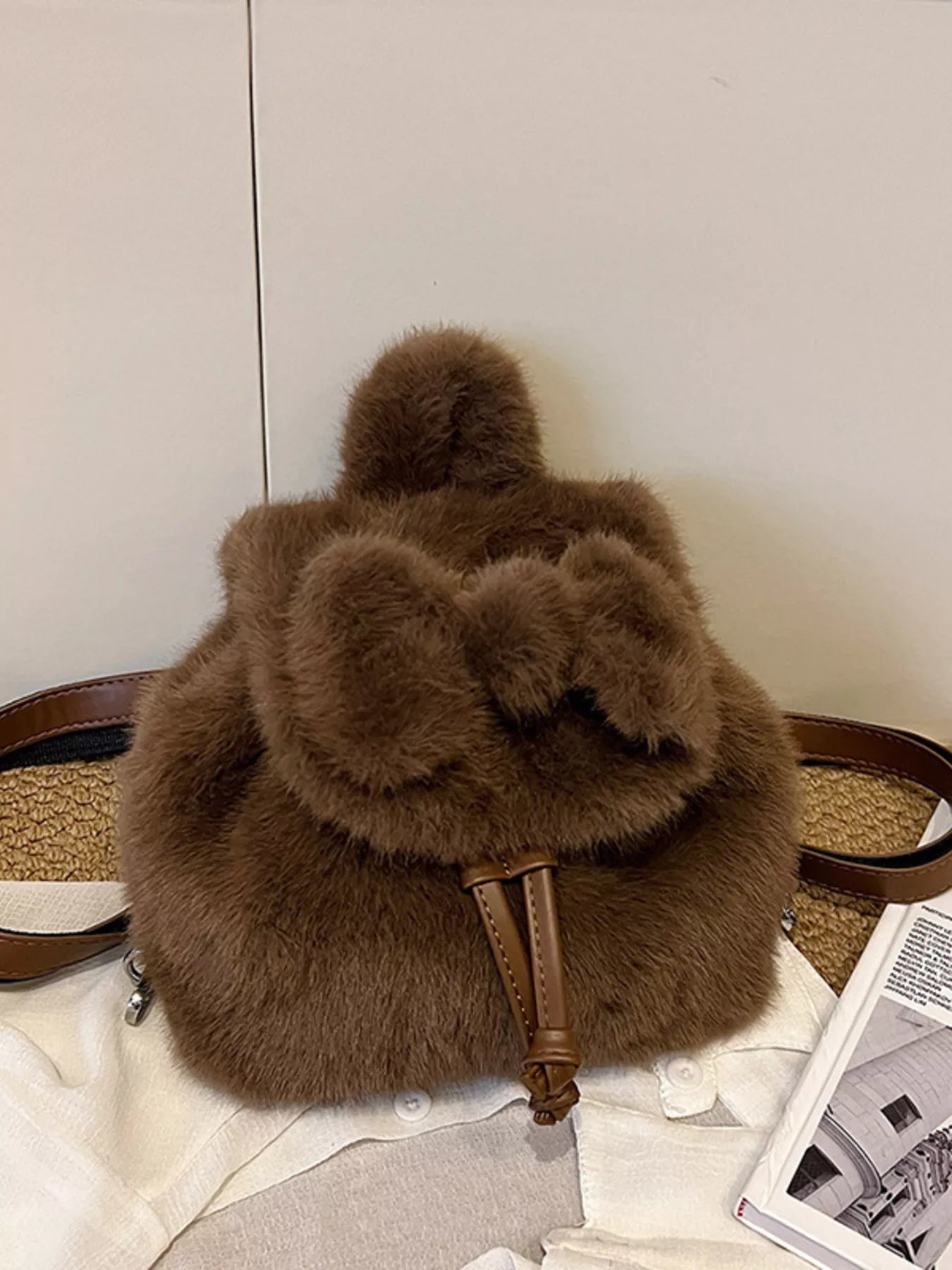 Brown fluffy backpack on a light-colored surface with a neutral background