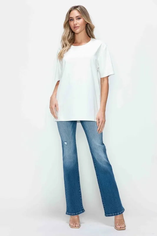 Woman wearing a white top and blue jeans on a white background