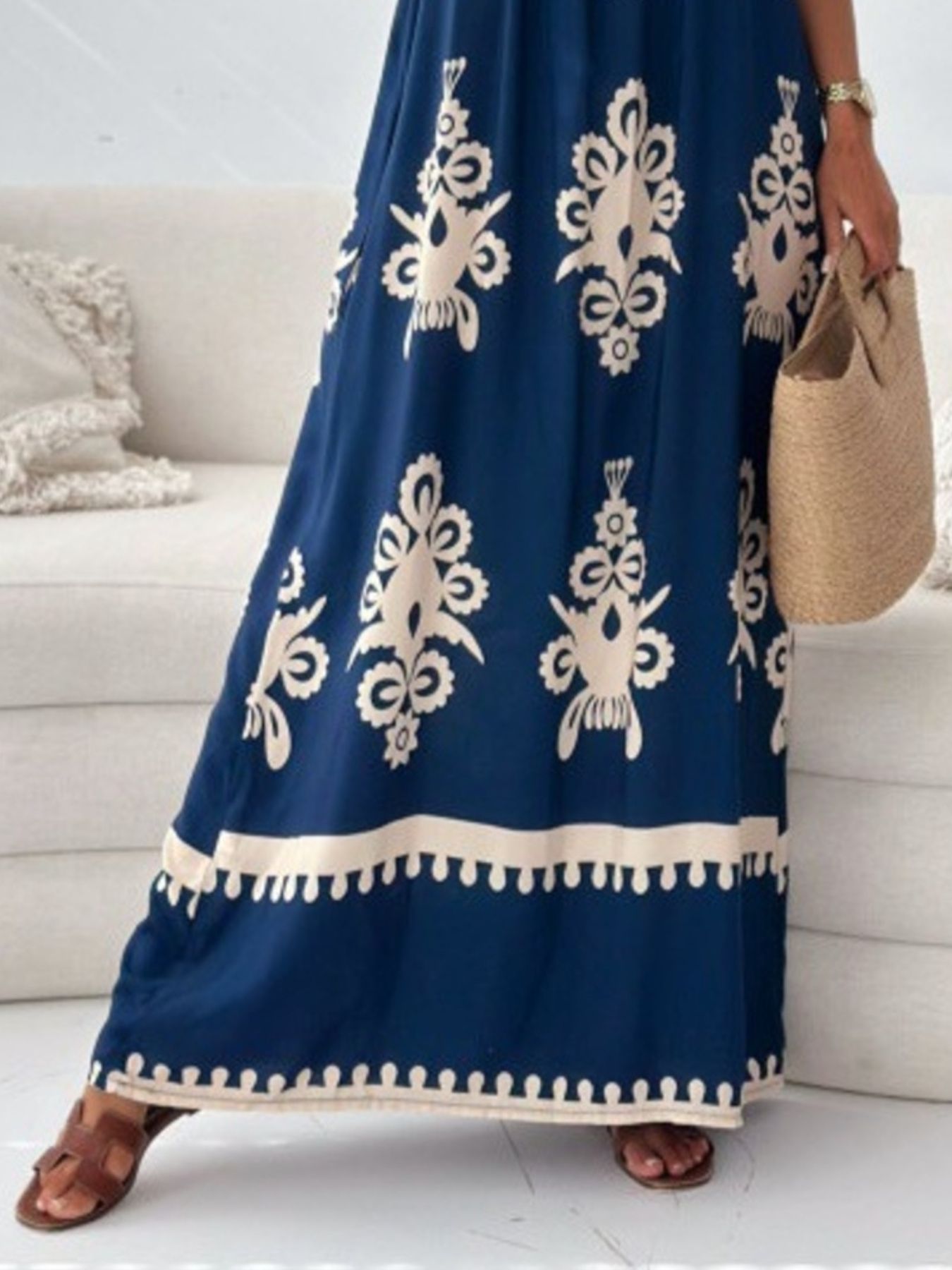 Person wearing a blue dress with white patterns in a living room setting