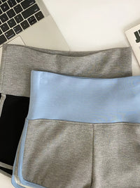 Gray and blue fabric swatch on a desk with a laptop and notebook.