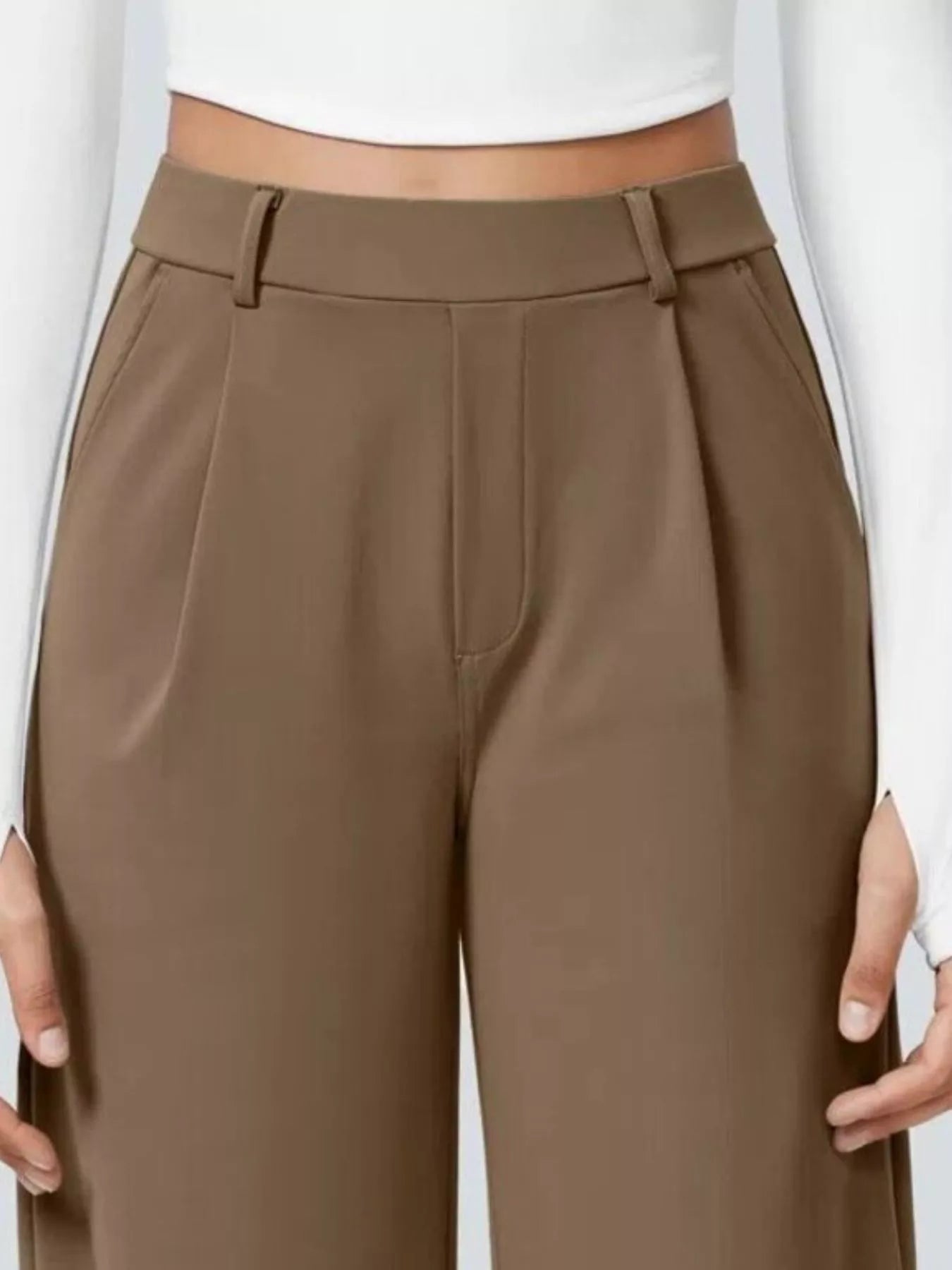 Brown pants worn by a person on a white background