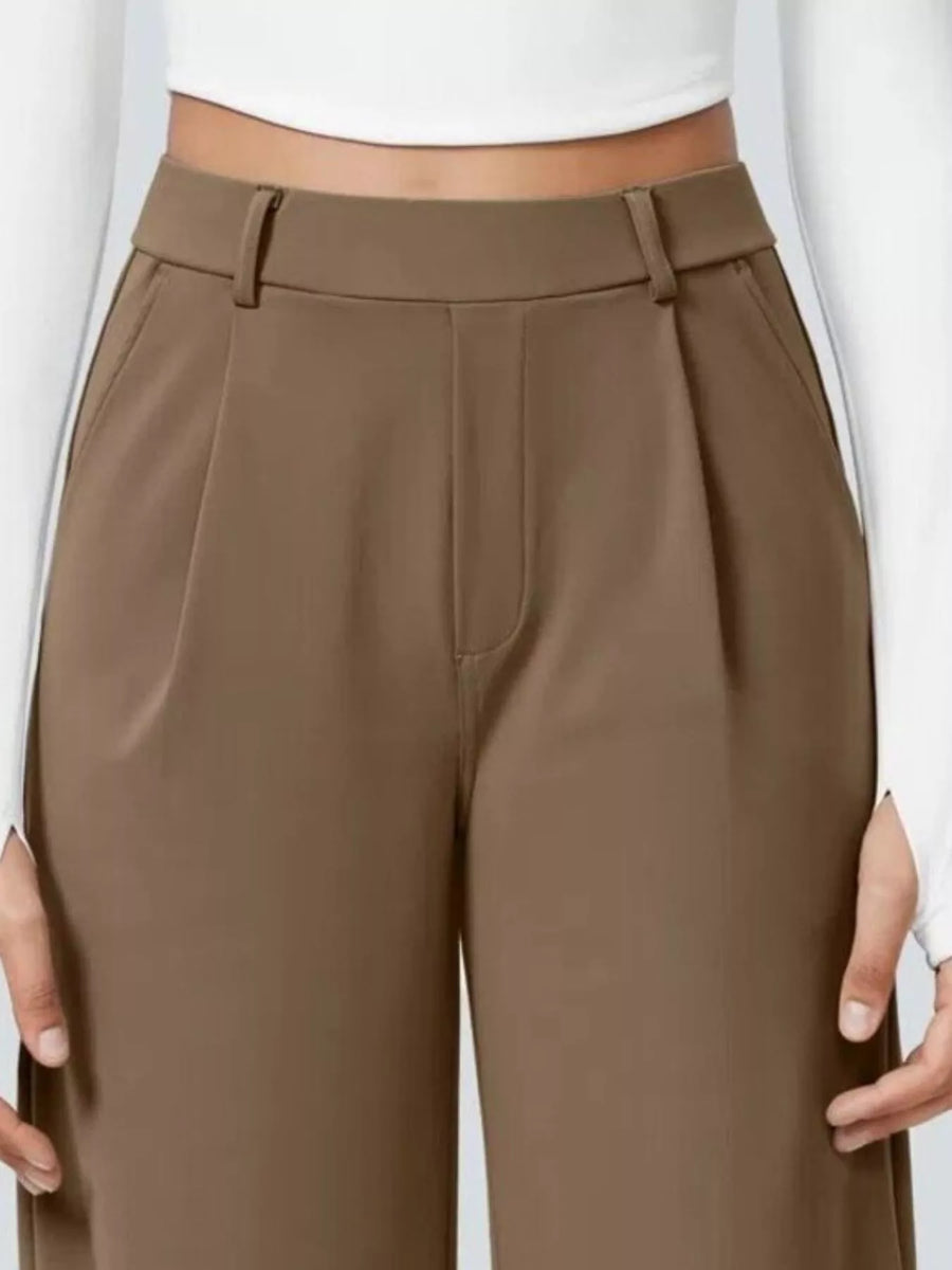 Brown pants worn by a person on a white background