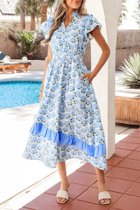 Woman wearing a blue floral dress by a poolside