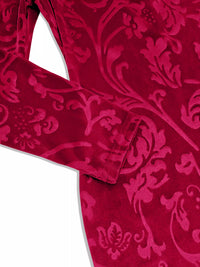 Close-up of a red velvet garment with intricate floral pattern