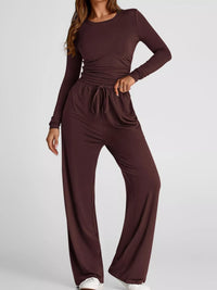 Brown jumpsuit worn by a model on a white background