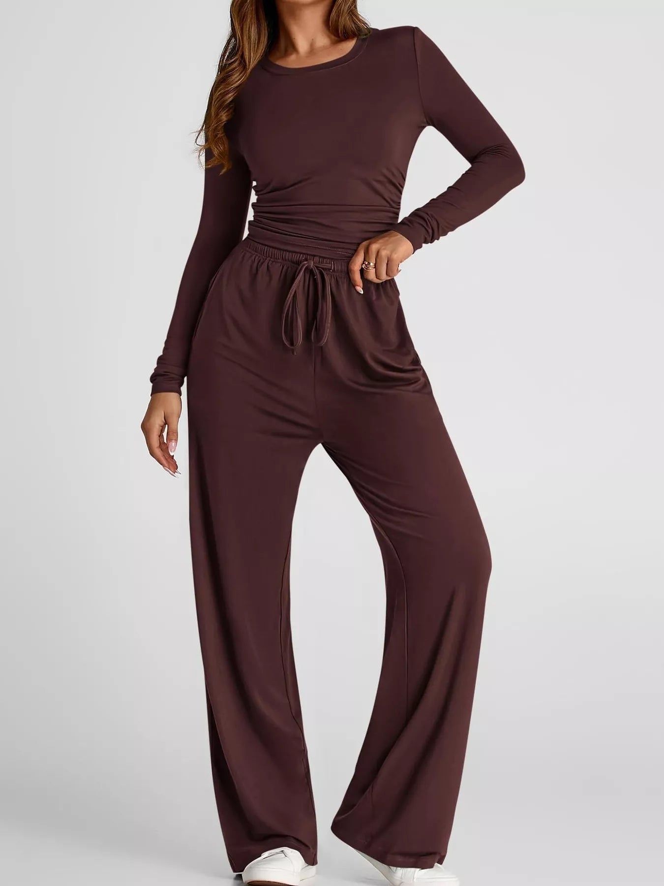 Brown jumpsuit worn by a model on a white background