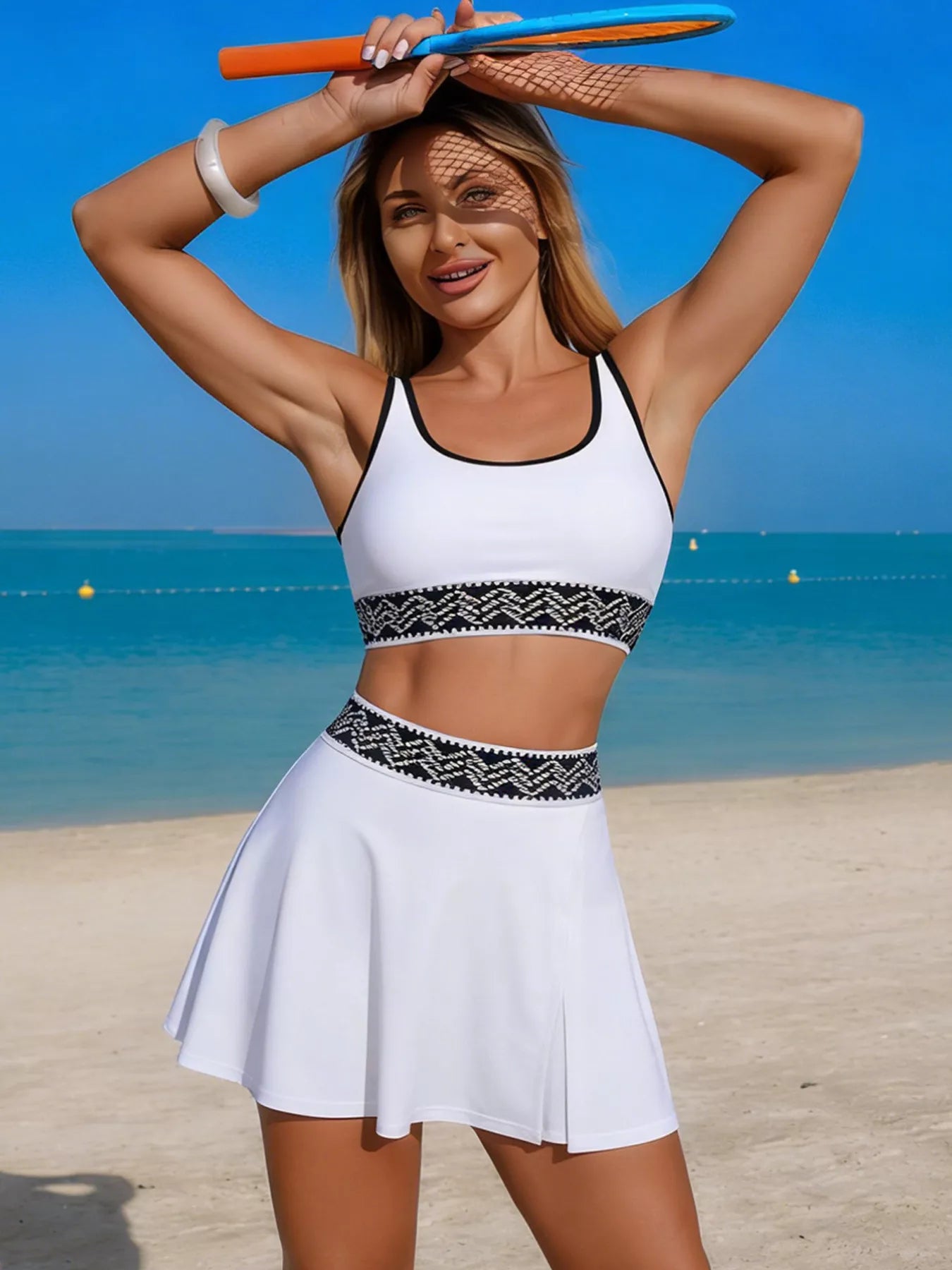 Woman in a white sports outfit with a black pattern on a beach