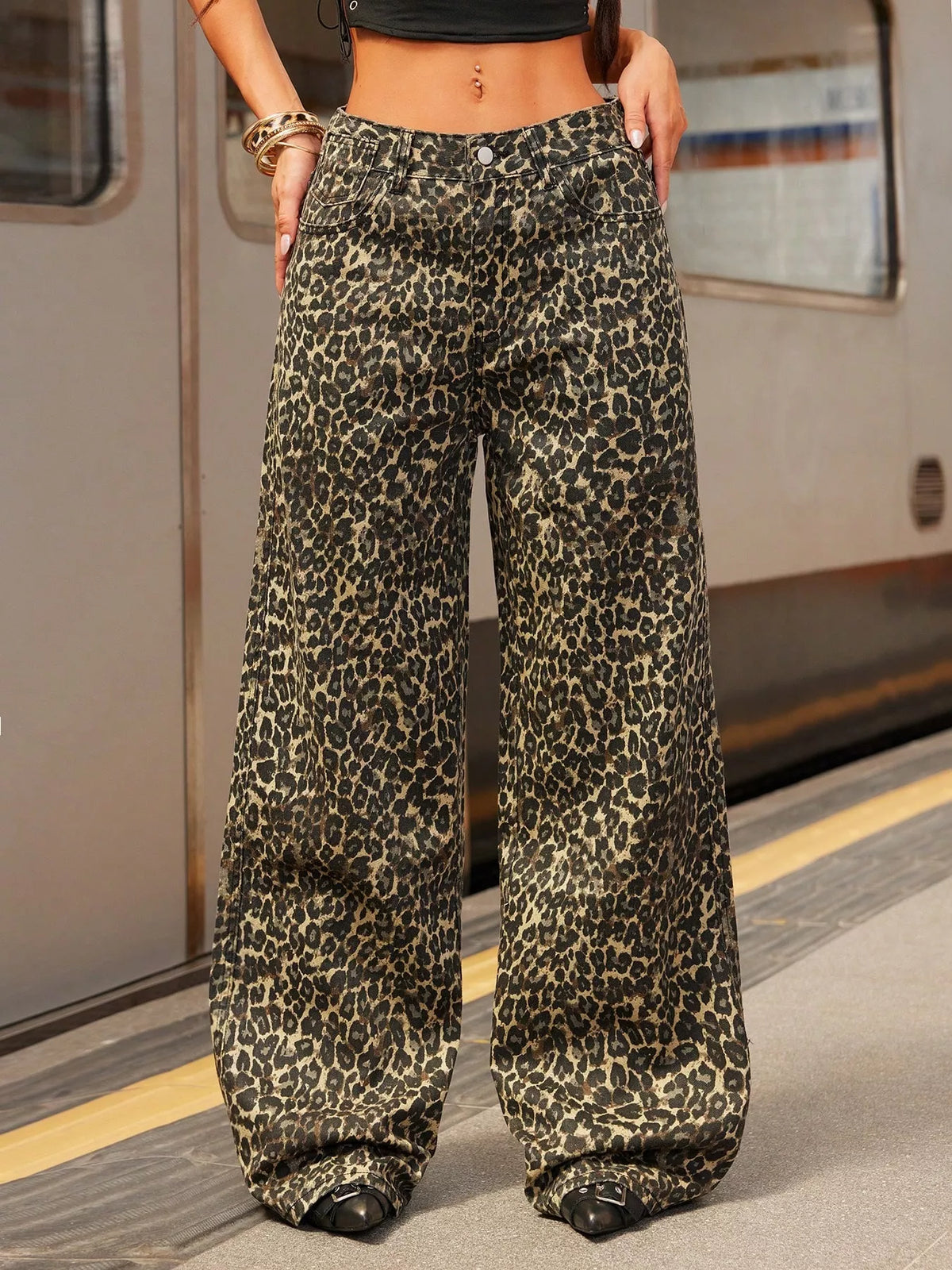 Person wearing leopard print pants on a subway platform