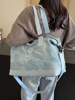 Person holding a light blue duffel bag with a marble pattern.