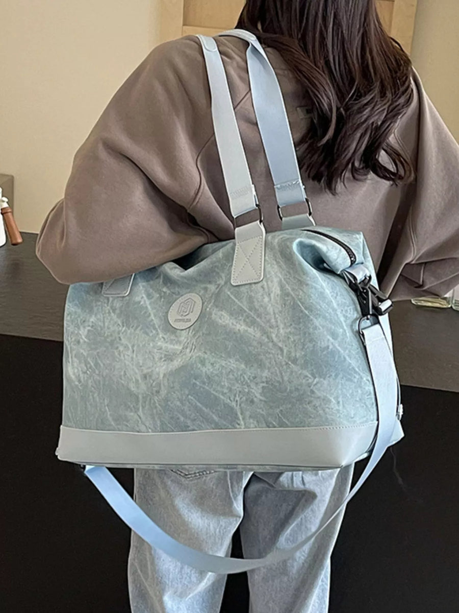 Person holding a light blue duffel bag with a marble pattern.
