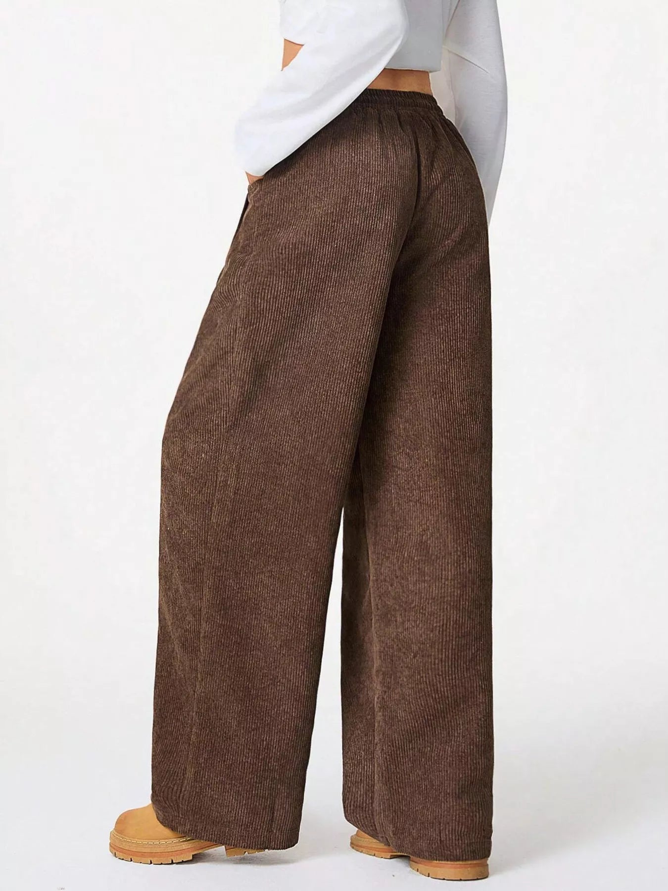 Brown wide-leg pants worn by a person on a white background