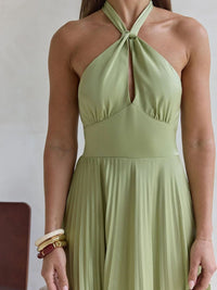 Green halter neck dress worn by a person on a plain background