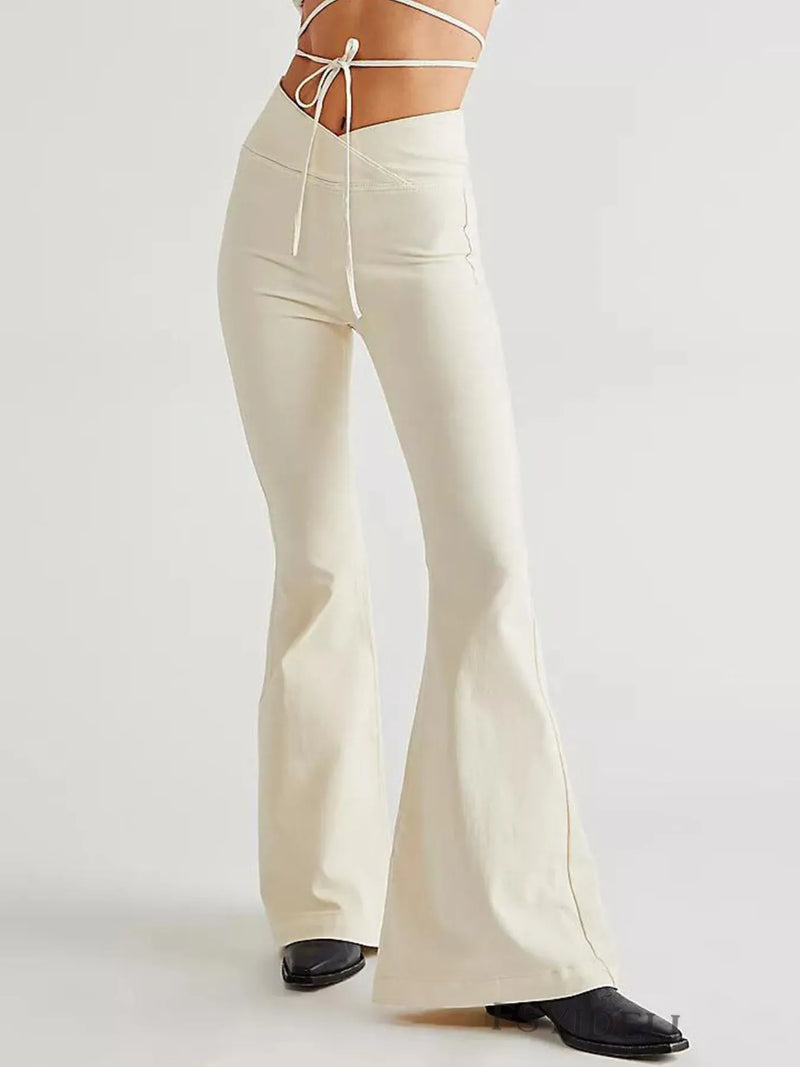 White flared pants worn by a person on a light gray background