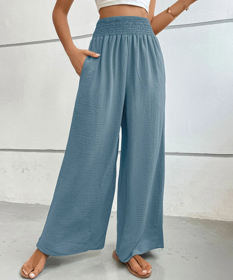 Blue wide-leg pants worn by a person on a light gray background