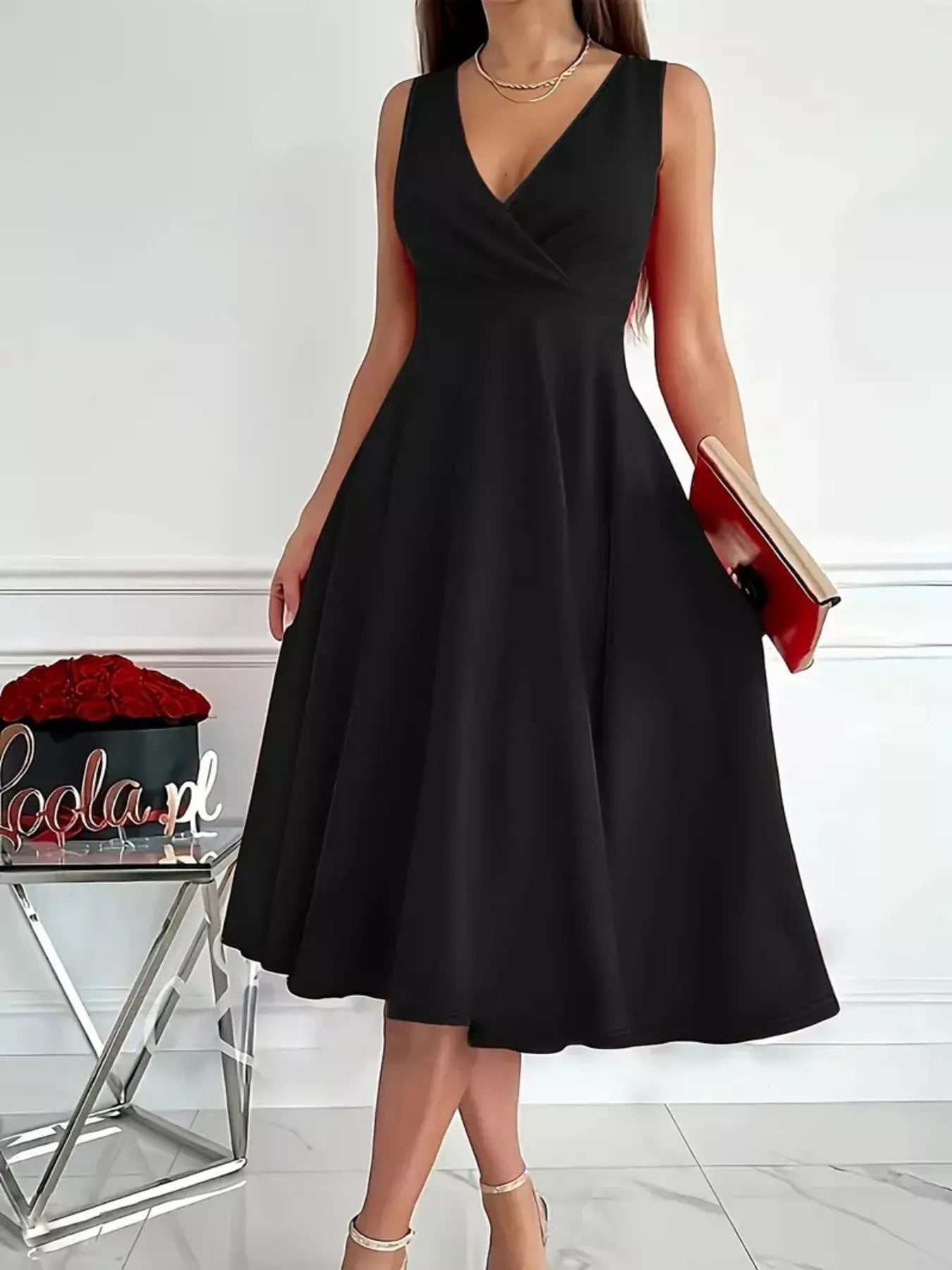 Black sleeveless dress worn by a person on a white background
