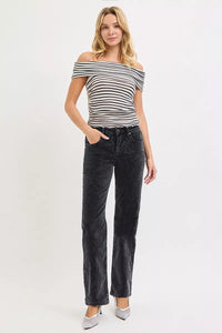 Woman wearing a black and white striped top and black jeans on a white background